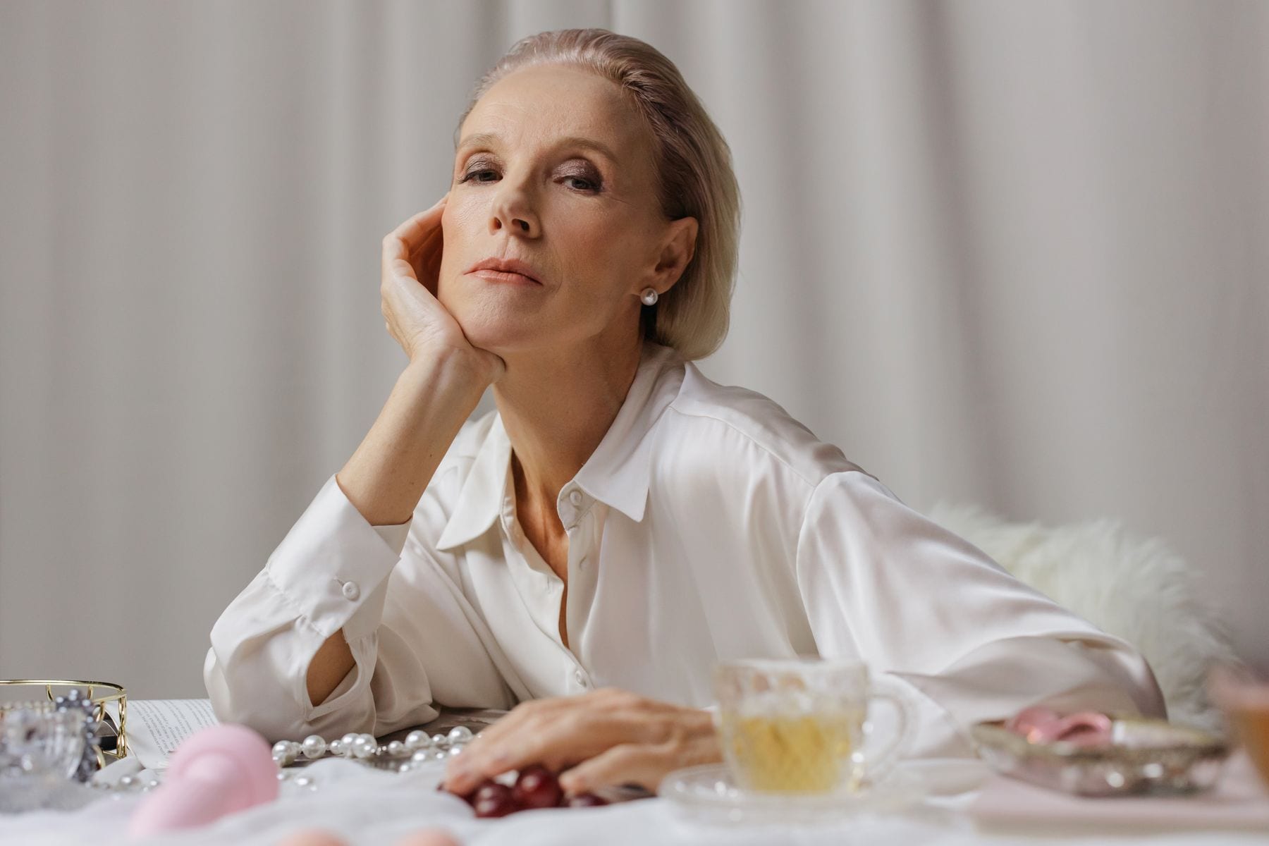 A woman resting her chin on her hand in soft natural light
