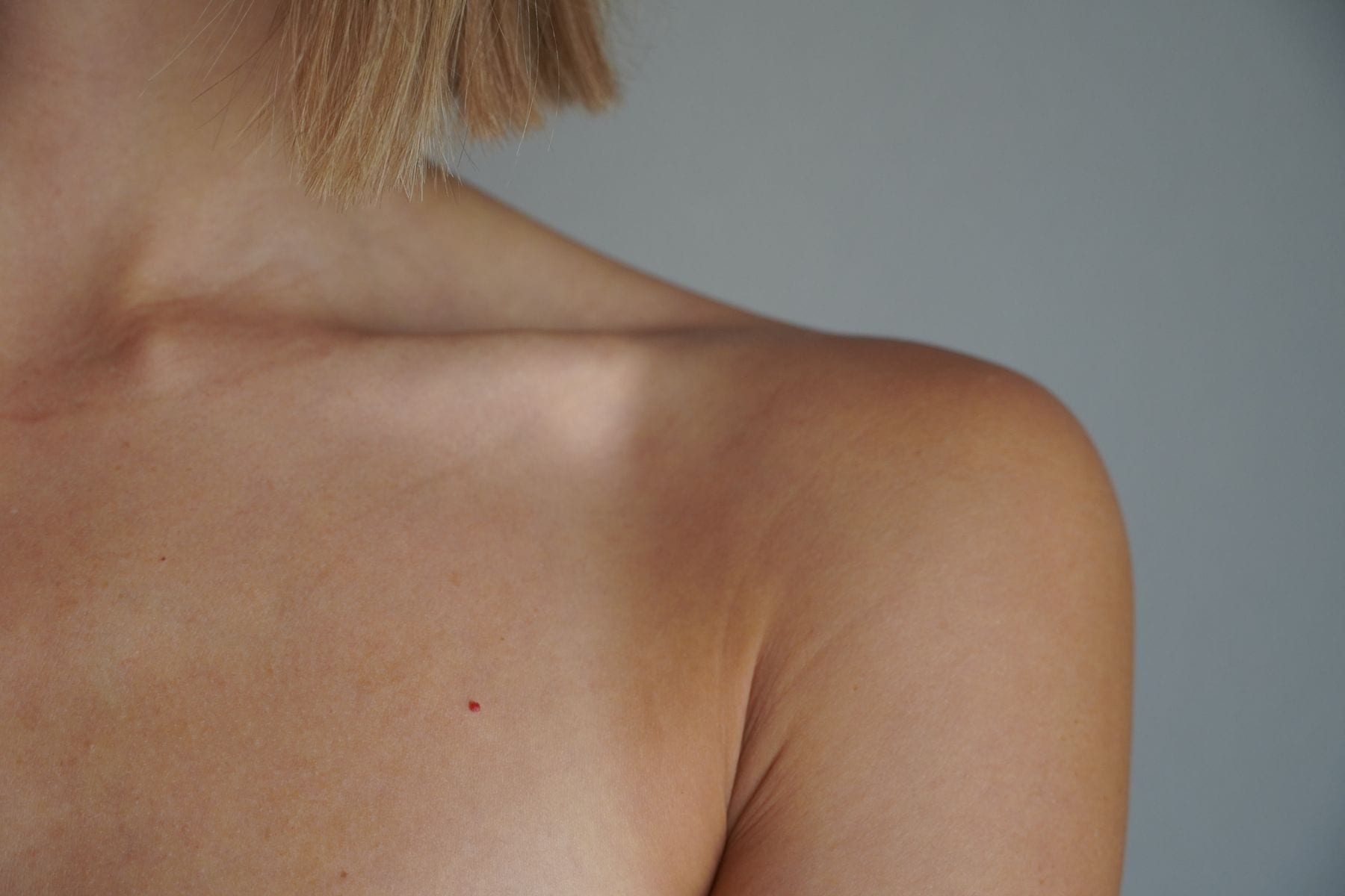 Soft natural light across a shoulder and collarbone, in close detail